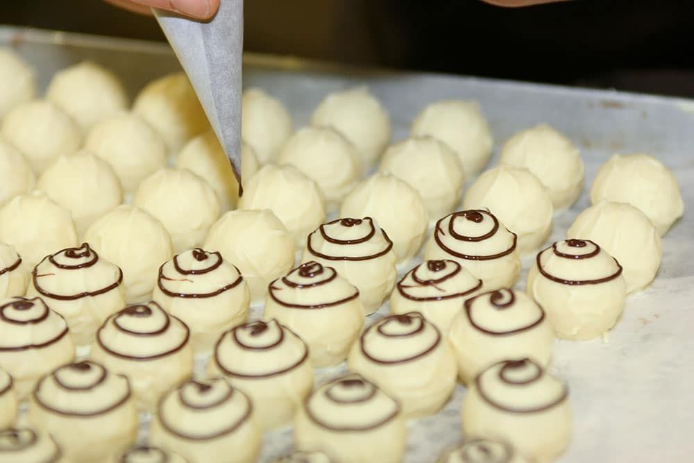Weiße Trockenbeer Auslese Pralinen von Schell Schokoladen werden garniert mit edelherber Schokolade.