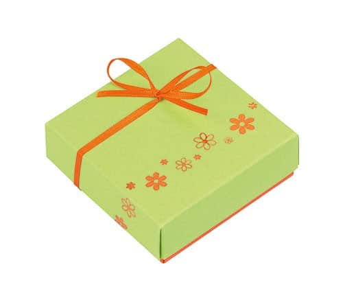 4er Schachtel Ostern von Schell Schokoladen ist befüllt mit Pralinen aus der Kreation "Rund um den Wein", die Pralinen befinden sich in einer grünen Schachtel oben um die Schachtel herum ist eine weiße Schleife mit Blumen und einem orangenen Band zu sehen unten an der Schachtel sind noch orangene Blumen zu erkennen