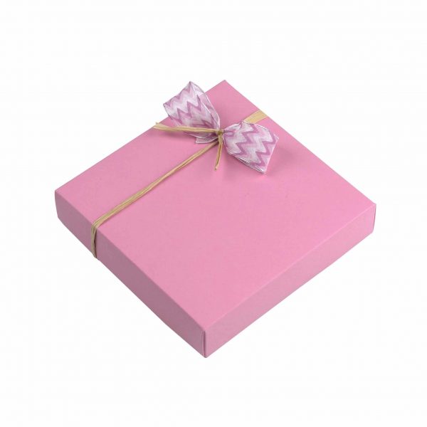 9er Schachtel "Rosenzauber" von Schell Schokoladen hat eine pinke Verpackung mit einer pinken Schleife an einem Strohband.