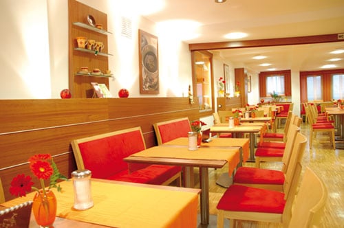 Es ist unser Schell Cafe von innen zu sehen mit Ihren wundervollen Sitzplätzen und Tischen.