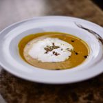 Es ist unsere wundervolle Kürbis suppe abgebildet in einem weißen Teller.