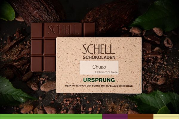 Es ist die Chuao Schokolade zu sehen über der Schokolade ist die beige Verpackung wo der Name und unser Logo abgebildet ist.