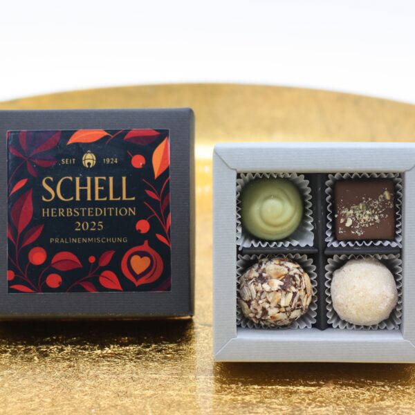 Geöffnete Schachtel der Schell Herbstedition 2025 Pralinenmischung, mit Deckel nebendran.
